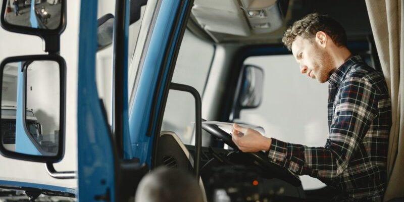 Lorry driver reading in cab